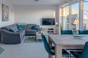 a living room with a table and a couch at 5 Sterne Penthouse DeichSuite in Büsum