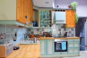 a kitchen with green cabinets and wooden counters at Fairy Glen Guest Suite in Rostrevor