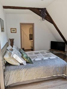 een slaapkamer met een bed met kussens erop bij chez Coco in Riquewihr