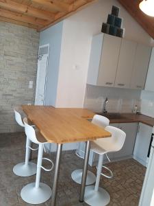 a kitchen with a wooden table and white chairs at Fotini Studios in Paleokastritsa
