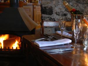 a table with wine glasses and a fire place at The Holcombe in Holcombe