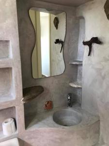 a bathroom with a sink and a mirror at Afrodite Hotel in Tinos