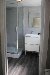 a bathroom with a shower and a sink and a mirror at The Five Pilchards Inn in Helston