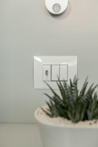 a lightswitch on a wall next to a plant at ODA Aparthotel Shkodër in Shkodër +26 photos