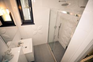 La salle de bains est pourvue d'une douche et d'un lavabo. dans l'établissement White Luna Mamaia, à Mamaia