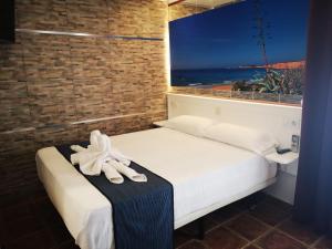 a bedroom with a bed and a window with a view at Hostal Costa De La Luz in Conil de la Frontera