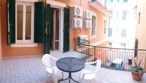 a patio with a table and chairs on a balcony at HOTEL MALIBU in Spotorno