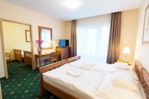 Postel nebo postele na pokoji v ubytování Orchidea Hotel Lipót