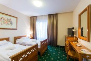 Postel nebo postele na pokoji v ubytování Orchidea Hotel Lipót