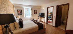a bedroom with a bed and a bathroom with a television at Casa do Criativo ® Bed&Breakfast in Almada