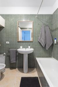 y baño con lavabo, bañera y espejo. en Home2Book Cozy Apartment Puertito, Wifi en Puertito de Güímar