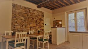 a dining room with a stone wall and a table and chairs at Il Tiglio Jacuzzi&Sauna in Lucca