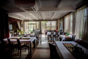 a dining room with tables and chairs and windows at Restauracja Sonata in Zwierzyniec