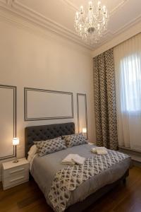 a bedroom with a large bed with a chandelier at Il Valentino Luxury Houses in Florence