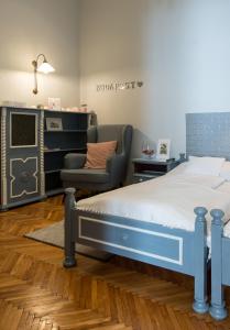 ein Schlafzimmer mit einem Bett und einem Stuhl in der Unterkunft City Heart Apartments in Budapest