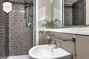 a bathroom with a sink and a shower and a mirror at Ramé Suites in Bergamo