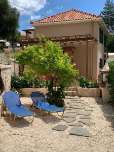 dwa krzesła i drzewo na podwórku w obiekcie Ainos Retreat w mieście Kefalonia
