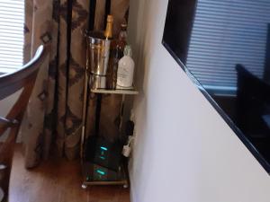 a corner of a room with a shelf with bottles on it at Bishops Park Apartment in Inverness