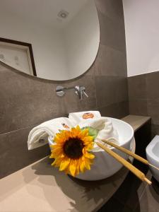 um girassol sentado em cima de um lavatório na casa de banho em B&B Moresco em Cattolica