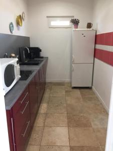 eine Küche mit einem weißen Kühlschrank und einer Mikrowelle in der Unterkunft LA BELLE ETOILE in Auneau
