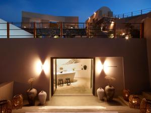a room with two large vases in front of a building at Melidonia Suites in Akrotiri
