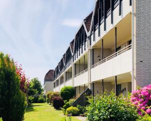 an external view of a building with a garden at Ferienwohnung Bolle in Hooksiel
