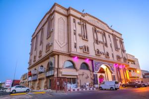 a large building with cars parked in front of it at الارجوان الراقية in Yanbu