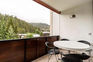 a balcony with a table and chairs and a view at Rancho Apartment in Laax
