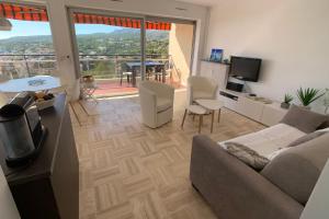 un salon avec un canapé, une table et une télévision dans l'établissement GALETS BLEUS by K6 Conciergerie Prestige, à Cassis