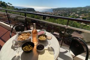 une table avec des verres à vin et de la nourriture sur un balcon dans l'établissement GALETS BLEUS by K6 Conciergerie Prestige, à Cassis