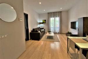 ein Wohnzimmer mit einem Sofa und einem Tisch in der Unterkunft Fisa Rentals Gran Via Apartments in Barcelona