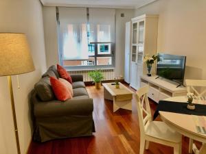 a living room with a couch and a dining room table at Apartamento Europa Jardín in Oviedo