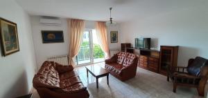 un salon avec des canapés, une télévision et une fenêtre dans l'établissement Apartment Nautica Topla, à Herceg-Novi 4 autres photos