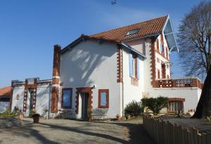 a white house with a brown roof at Villa Madura in Saint-Michel-Chef-Chef