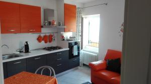 uma cozinha com armários azuis e uma cadeira vermelha em Casa Novella em Revò