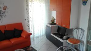 uma sala de estar com um sofá vermelho e uma televisão em Casa Novella em Revò