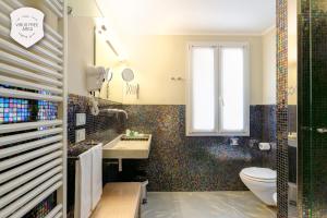 a bathroom with a toilet and a sink and a window at Il Convento Dei Fiori Di Seta in Bologna