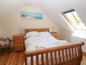 a bedroom with a large bed and a window at Garth Morthin The Stables in Morfa Bychan