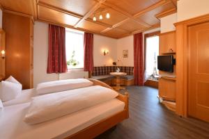 a hotel room with two beds and a television at Hotel Edelweiß Garni in Reit im Winkl