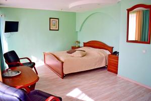 Schlafzimmer mit einem Bett, einem Schreibtisch und einem Stuhl in der Unterkunft Hotel Complex Vizit in Kozin
