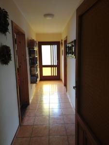 korytarz z drzwiami i podłogą wyłożoną kafelkami w obiekcie Biohof Am Turawa-See w mieście Szczedrzyk
