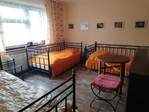 sypialnia z 2 łóżkami, stołem i krzesłem w obiekcie Biohof Am Turawa-See w mieście Szczedrzyk