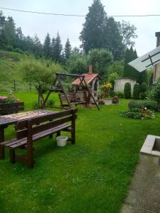 a garden with a bench and a gazebo at U STASI kwatery in Piwniczna-Zdrój