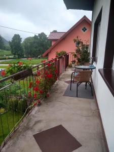 eine Terrasse mit einem Tisch und einem Zaun mit Blumen in der Unterkunft U STASI kwatery in Piwniczna-Zdrój