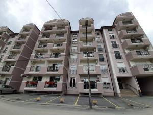 a large apartment building with balconies and a parking lot at SAN in Čačak