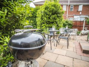 a grill in a yard with chairs and tables at Baytrees Hotel in Southport