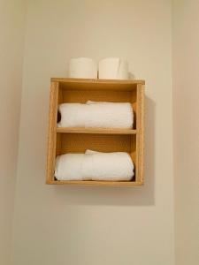 a shelf with towels and toilet paper on a wall at El Hoy in Tampa