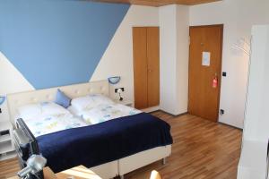 a bedroom with a bed with a blue wall at Hotel Restaurant Post Italia in Albstadt +15 photos