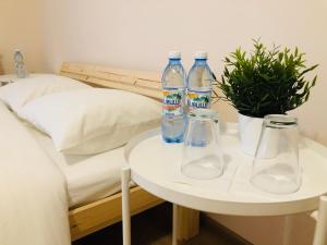 drei Flaschen Wasser auf einem Tisch neben einem Bett in der Unterkunft Апартаменти 21 in Uschhorod