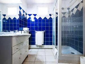 een blauw betegelde badkamer met een douche en een wastafel bij Auberge de la Tour in Aups
